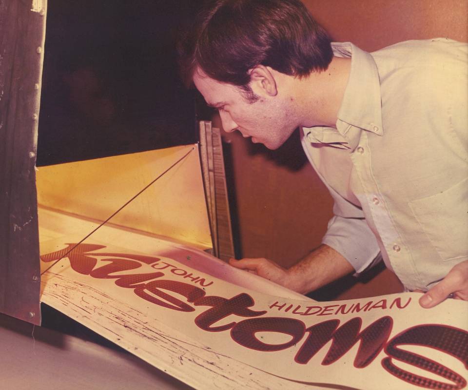 A man feeding a large banner into a machine